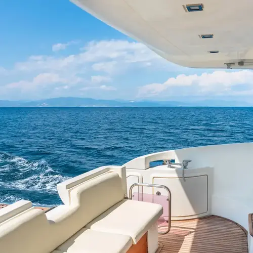 a white and brown boat with a view of the ocean