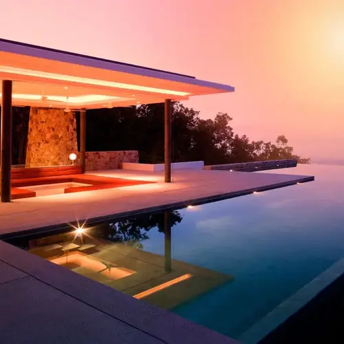 a pool with a building and a sunset