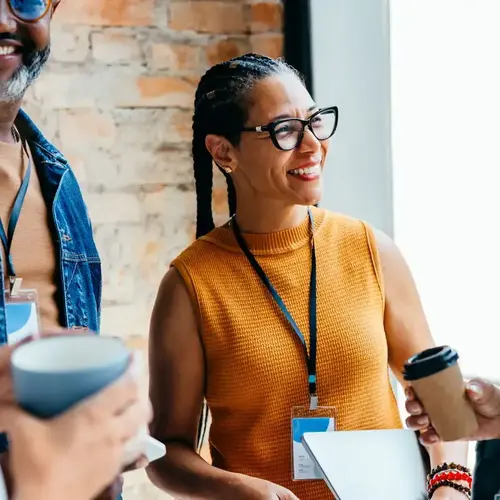 Group of business professionals enjoying a casual conversation with coffee stock
